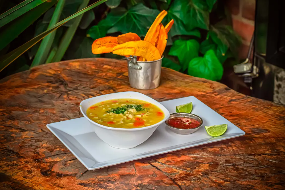 Imagen de una sopa acompañada con platano